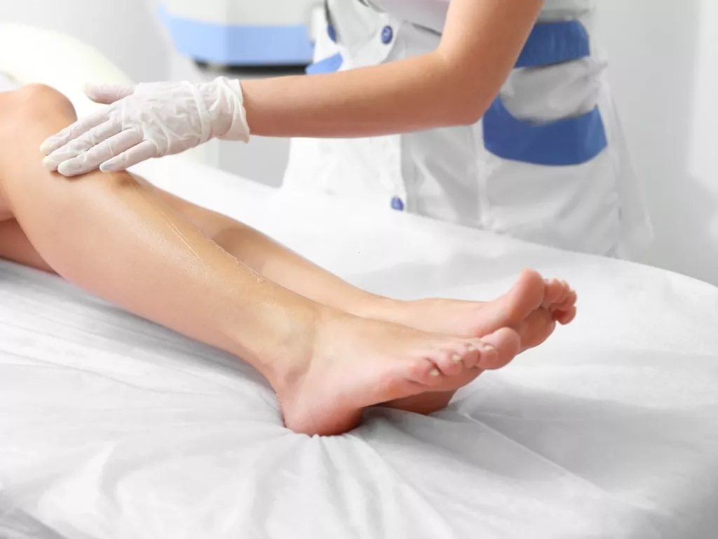 a woman getting ready to have leg laser session